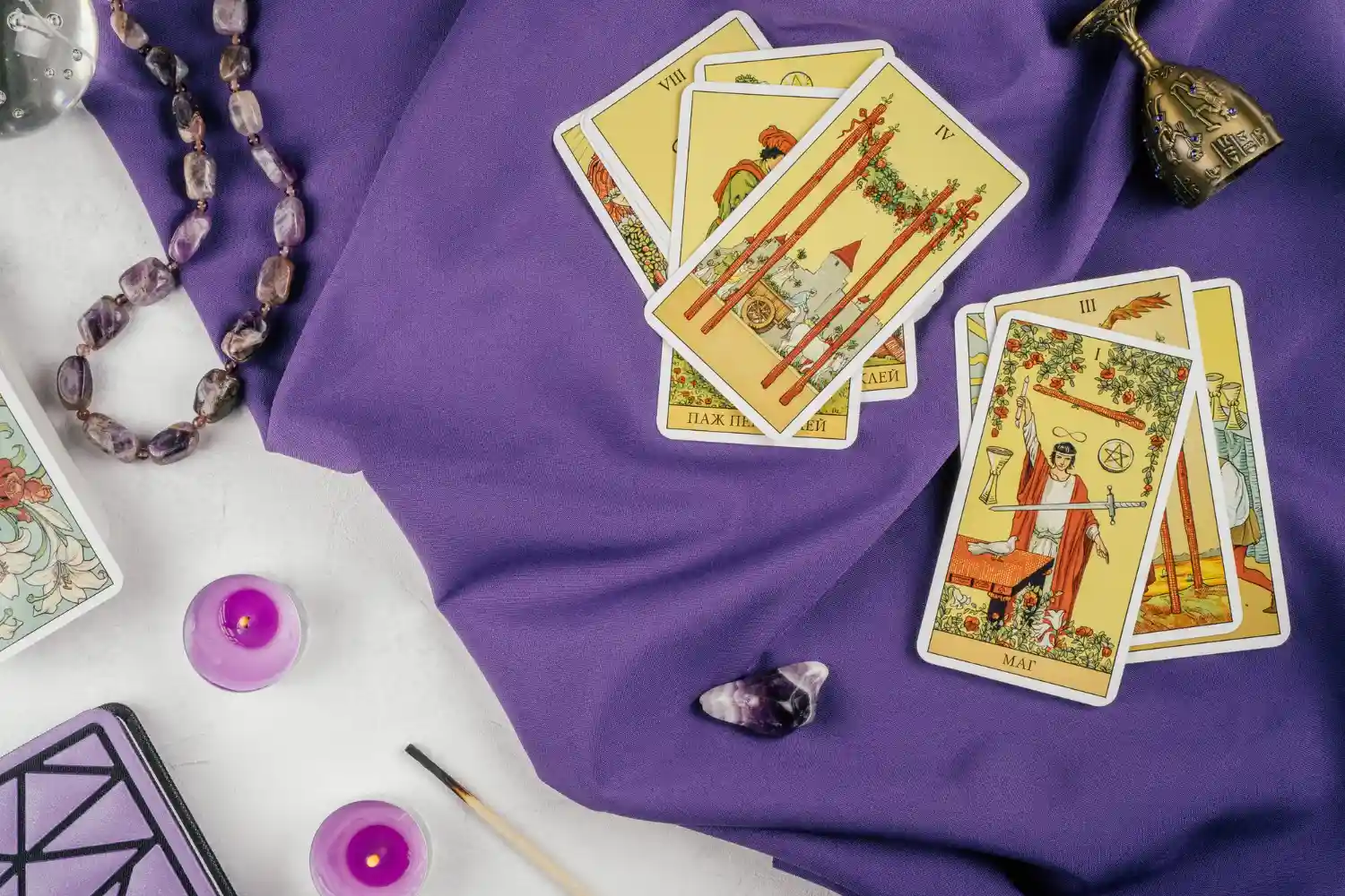 Sesión de tarot profesional en Montevideo con cartas Rider Waite sobre una mesa de terciopelo y un celular mostrando una consulta por WhatsApp.