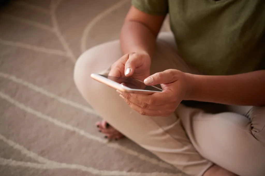 Una persona en su hogar sosteniendo un celular y consultando el tarot online en Uruguay mediante WhatsApp.